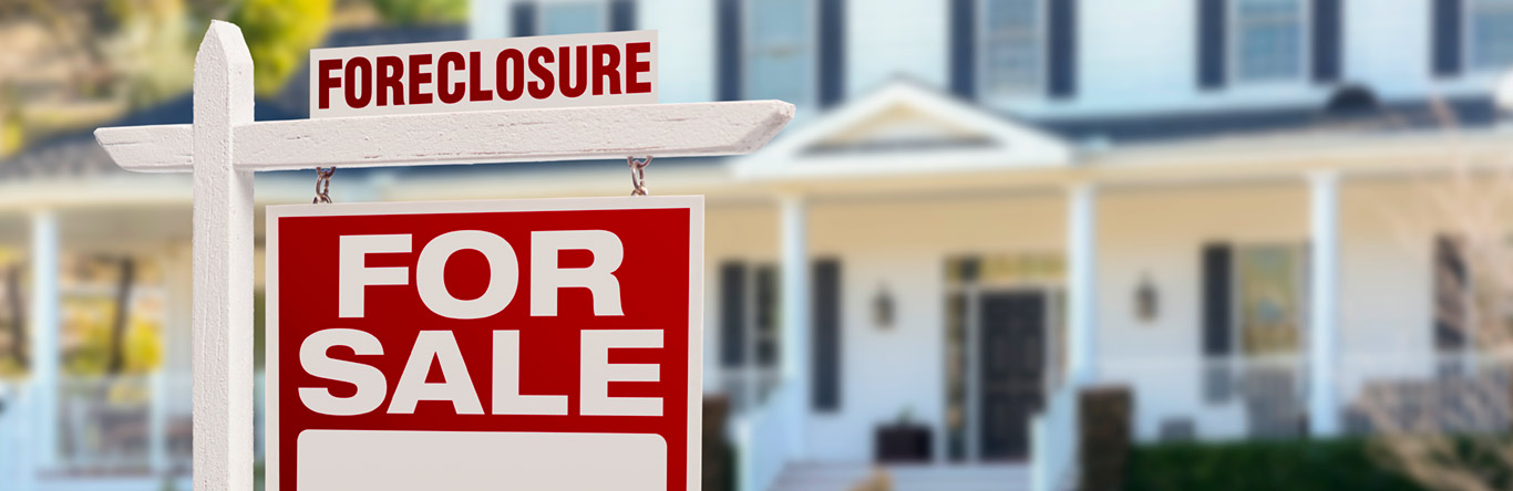 Foreclosure for sale sign in front of house