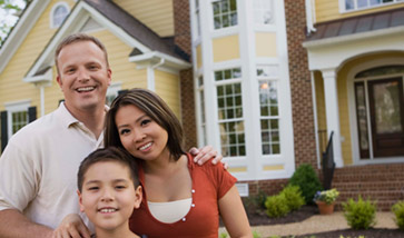 Smiling family outside home